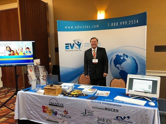 Scott standing at EVI booth at a Conference Scott standing at EVI booth at a Conference