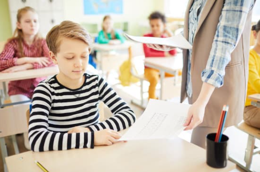 Teacher handing exams to students